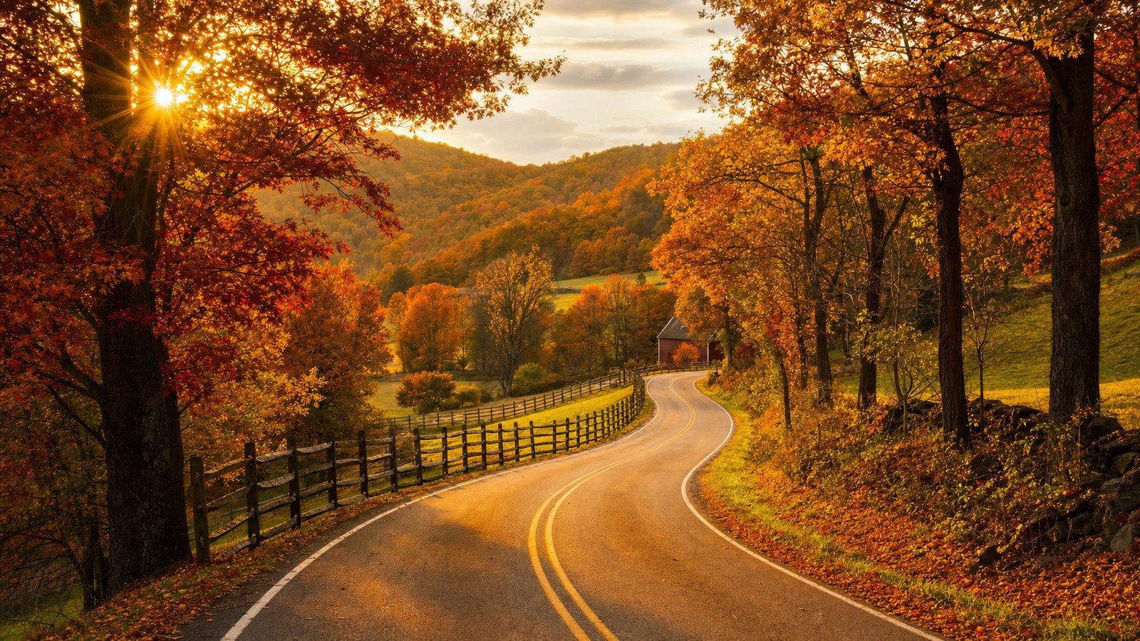 A winding two-lane country road in Ohio at golden hour, lined with mature maple and oak trees in peak fall color — deep reds, bright oranges, and yellows — with a small red barn and split-rail fence in the distance.